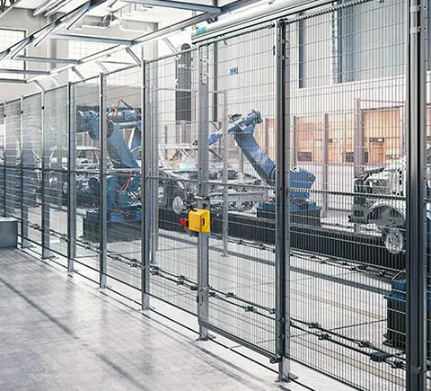 Automated robotic arms working behind Troax machine guarding in a high-tech industrial manufacturing facility